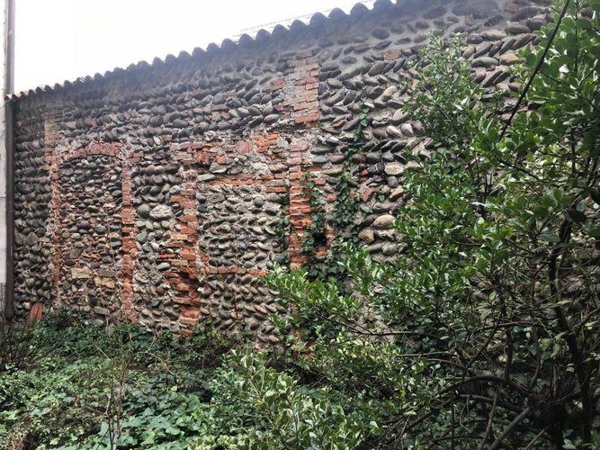 Porzione cielo/terra di palazzina storica con muro in sassi. Villa di Serio