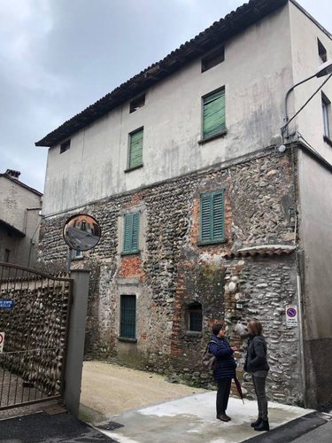 Porzione cielo/terra di palazzina storica con muro in sassi. Villa di Serio