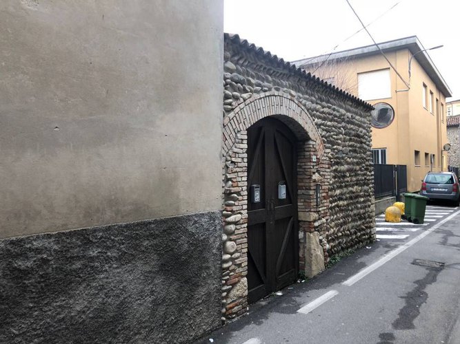 Porzione cielo/terra di palazzina storica con muro in sassi. Villa di Serio