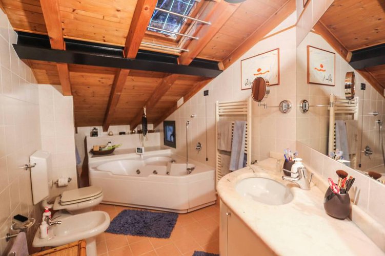 Accogliente mansarda con travi a vista e camino. Bergamo